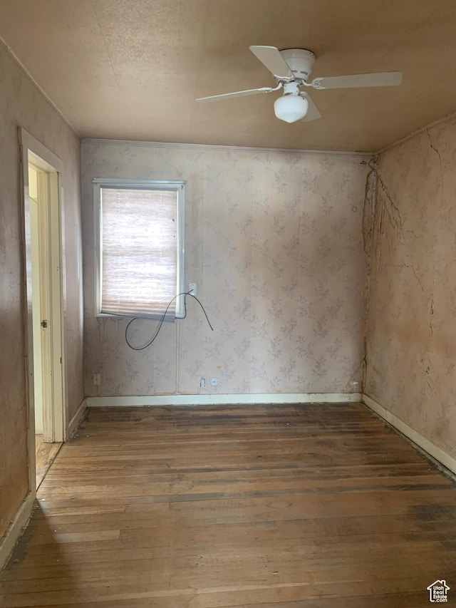 empty room featuring a ceiling fan, light wood-style floors, baseboards, and wallpapered walls