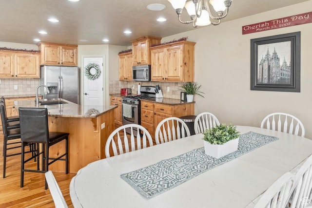 955 W 720 N, Tremonton, UT 84337 - kitchen with a chandelier, a breakfast bar area, light wood-type flooring, stainless steel appliances, and recessed lighting