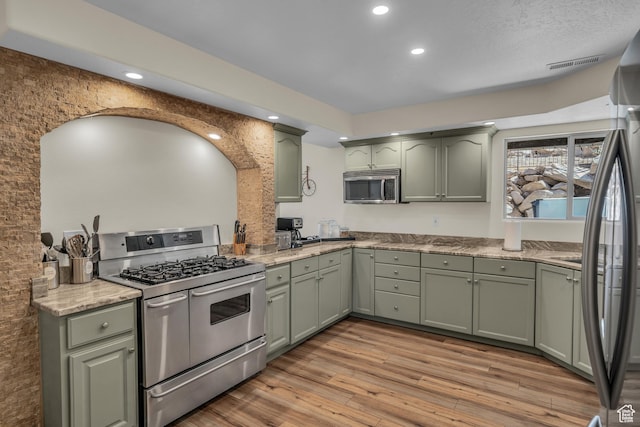 1060 E Summit Ridge Dr, St George, UT 84790 - kitchen with stainless steel appliances, light wood-style floors, and green cabinets