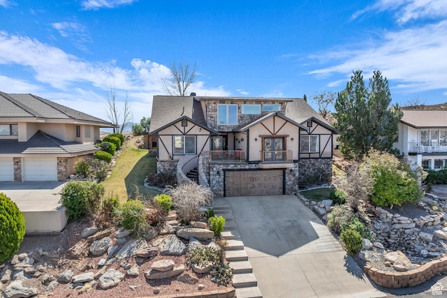 1060 E Summit Ridge Dr, St George, UT 84790 - tudor house featuring stairway, concrete driveway, roof with shingles, a garage, and stone siding