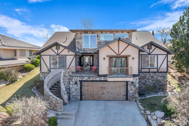 1060 E Summit Ridge Dr, St George, UT 84790 - tudor house with roof with shingles, stucco siding, concrete driveway, french doors, and stone siding