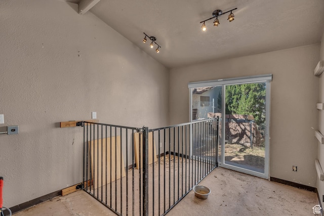 1060 E Summit Ridge Dr, St George, UT 84790 - hallway featuring a textured wall, baseboards, unfinished concrete floors, and vaulted ceiling