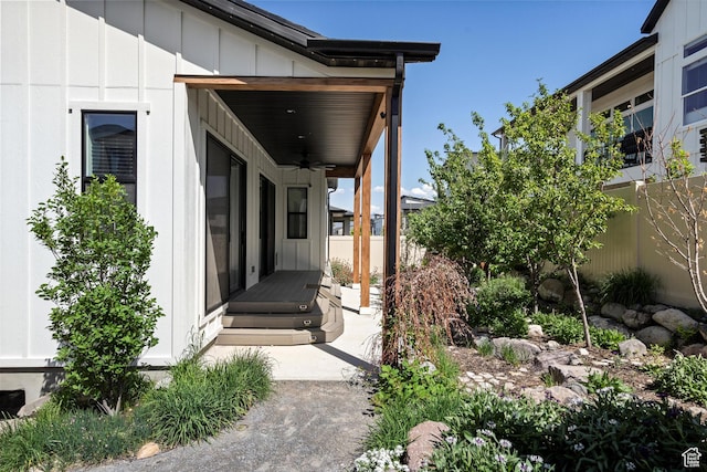 4823 W Mossley Dr, Herriman, UT 84096 - view of exterior entry with ceiling fan, board and batten siding, and fence