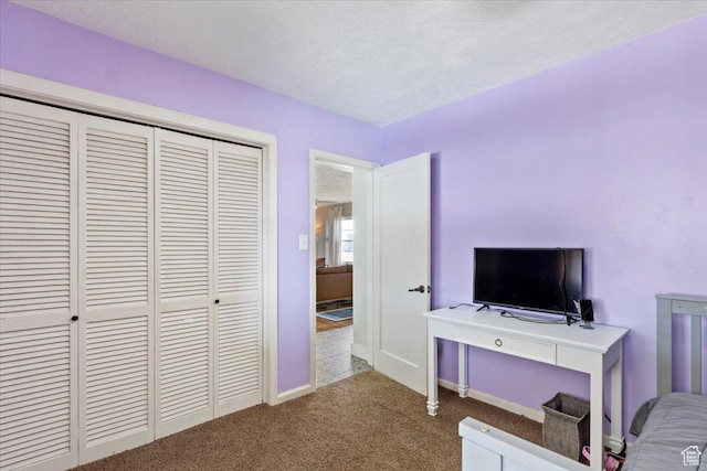 carpeted bedroom featuring a closet and a textured ceiling