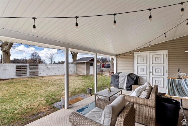 view of patio with fence, a shed, an outdoor hangout area, an outbuilding, and a grill