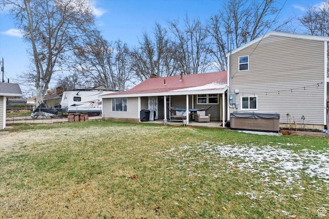 back of property featuring a patio, fence, a lawn, and a hot tub