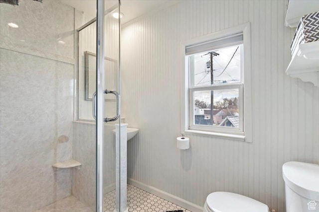 full bath with baseboards, toilet, and a stall shower