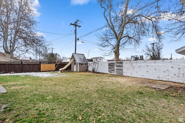 view of yard with an outbuilding, a fenced backyard, and a storage shed