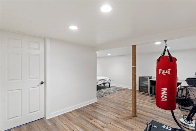 exercise area with light wood finished floors, recessed lighting, and baseboards
