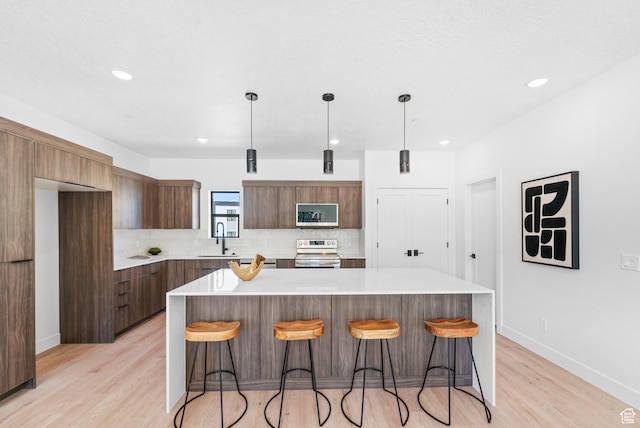 4386 S 900 E Unit 102, Millcreek, UT 84124 - kitchen with appliances with stainless steel finishes, modern cabinets, tasteful backsplash, light wood finished floors, and recessed lighting