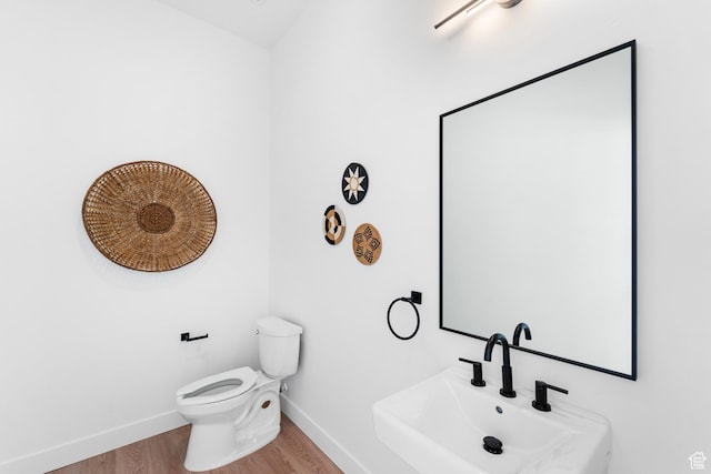 4386 S 900 E Unit 102, Millcreek, UT 84124 - half bath featuring wood finished floors, a sink, baseboards, and toilet