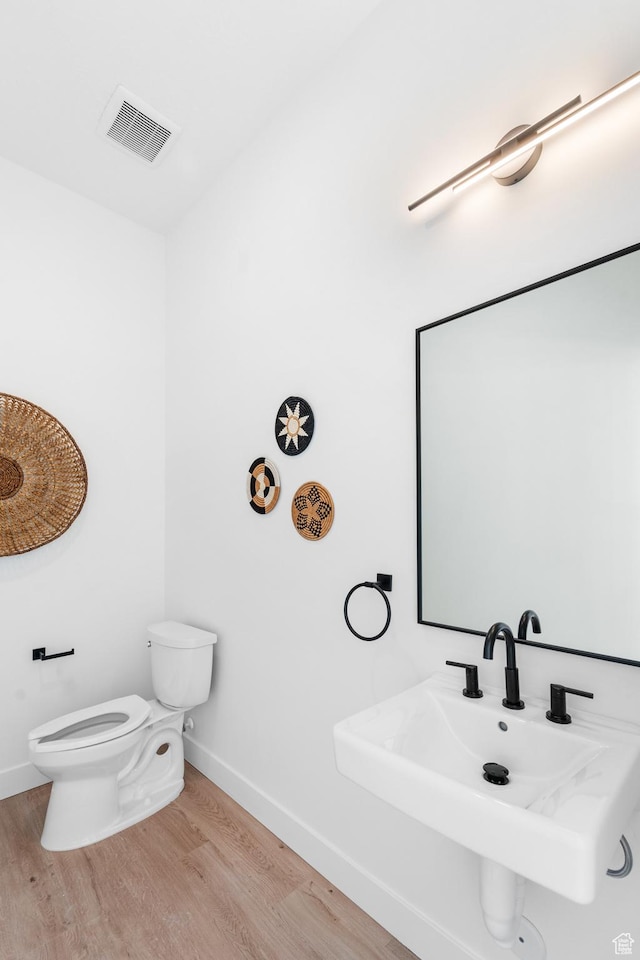 4386 S 900 E Unit 101, Millcreek, UT 84124 - bathroom with visible vents, toilet, a sink, wood finished floors, and baseboards
