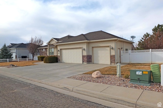 view of front of property featuring fence, concrete driveway, stucco siding, a garage, and a gate