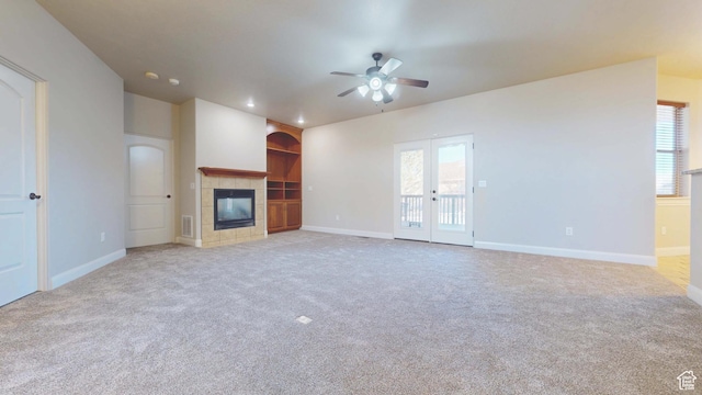 unfurnished living room featuring baseboards, visible vents, a fireplace, ceiling fan, and light colored carpet