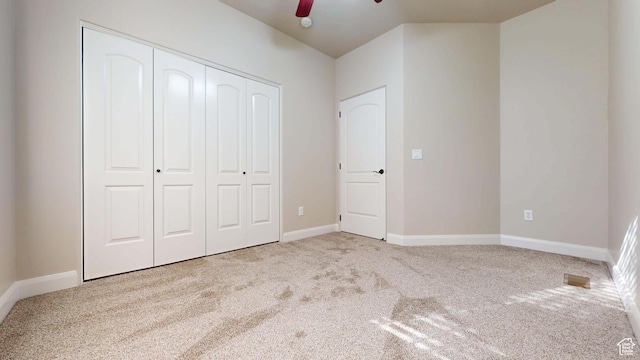unfurnished bedroom with baseboards, a closet, carpet floors, and ceiling fan
