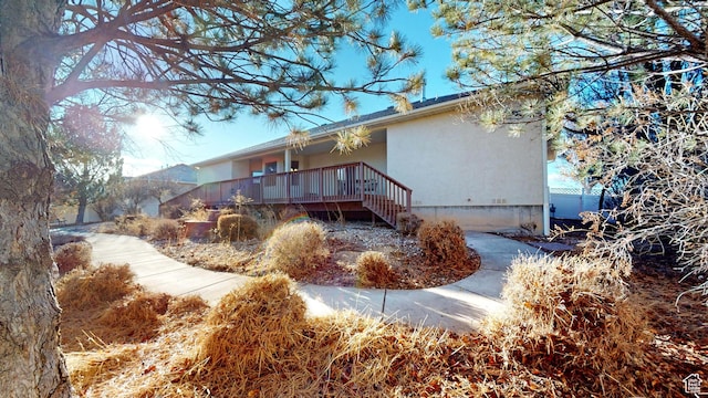 back of house featuring stucco siding and stairs