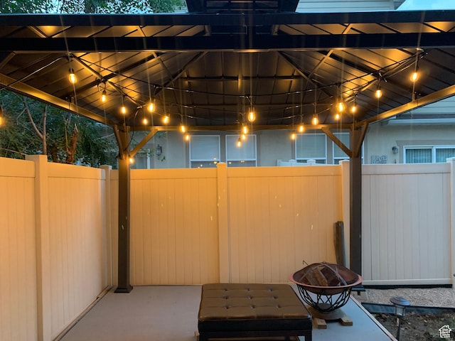 view of patio featuring fence, a gazebo, and an outdoor fire pit