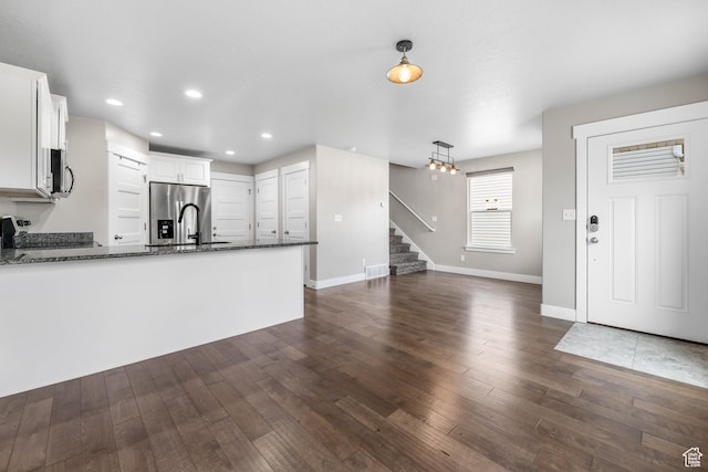 1848 E American Way Unit 2, Eagle Mountain, UT 84005 - kitchen with appliances with stainless steel finishes, a peninsula, dark wood-type flooring, dark stone countertops, and white cabinetry