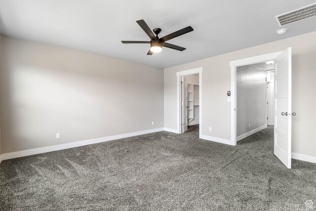 1848 E American Way Unit 2, Eagle Mountain, UT 84005 - unfurnished bedroom featuring baseboards, dark colored carpet, a walk in closet, and ceiling fan