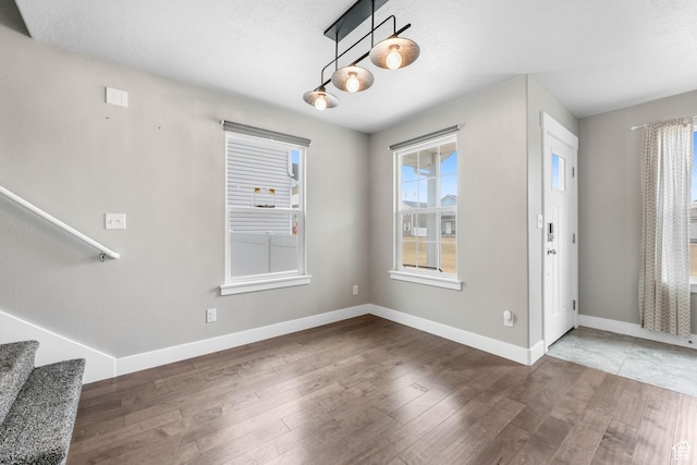 1848 E American Way Unit 2, Eagle Mountain, UT 84005 - unfurnished dining area featuring wood finished floors, baseboards, and stairway