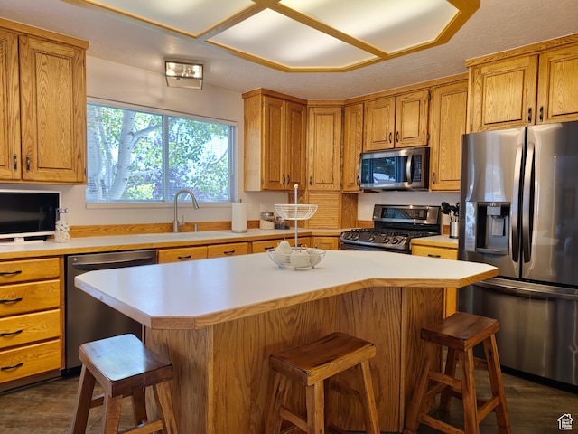 449 Billies Cir, Evanston, WY 82930 - kitchen with a kitchen island, a breakfast bar, a sink, light countertops, and appliances with stainless steel finishes