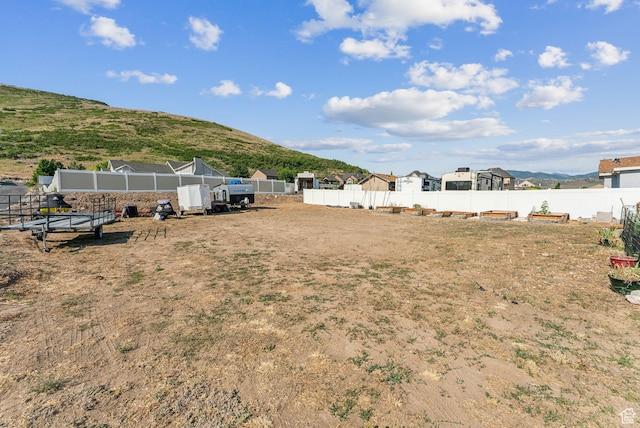view of yard featuring fence and a mountain view