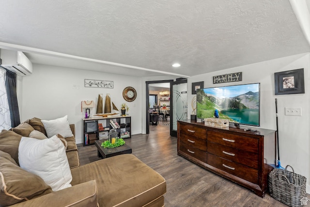 living room featuring dark wood finished floors, a textured ceiling, and a wall unit AC
