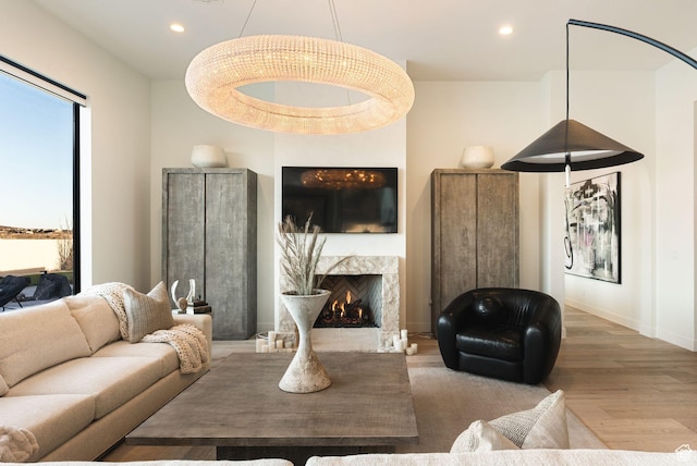 living room featuring recessed lighting, baseboards, wood finished floors, and a fireplace