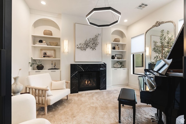 carpeted living area featuring recessed lighting, a premium fireplace, built in shelves, and visible vents