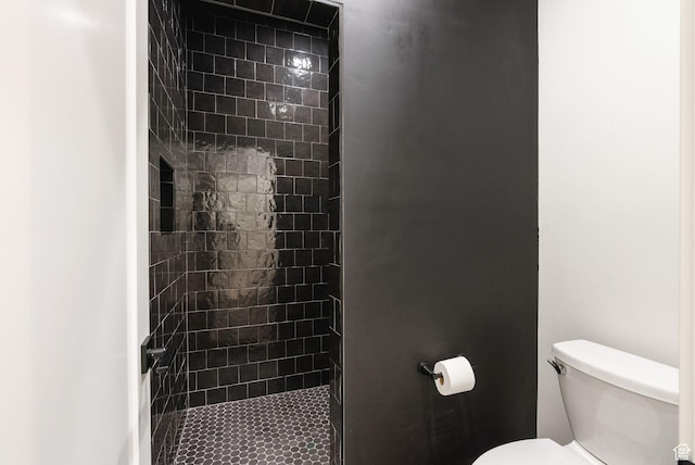 bathroom with toilet and a tile shower