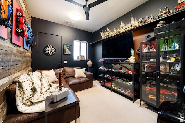 living area featuring visible vents, a ceiling fan, and carpet floors