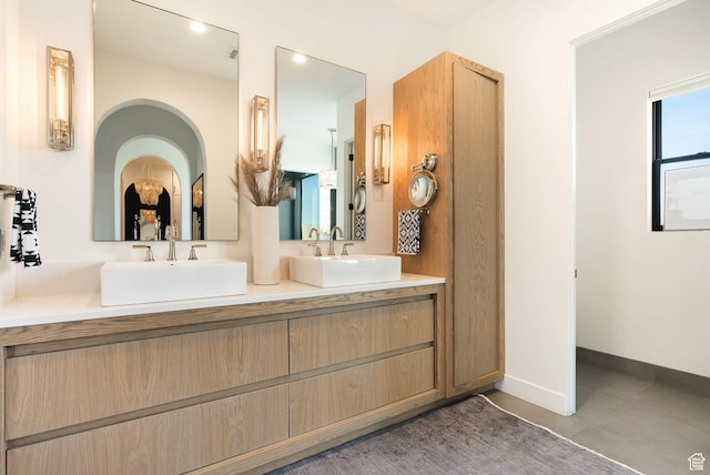 bathroom featuring double vanity, recessed lighting, baseboards, and a sink