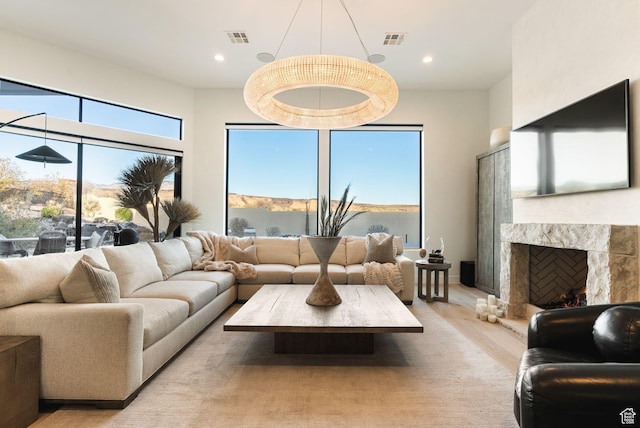 living room featuring light wood-style floors, visible vents, and a wealth of natural light