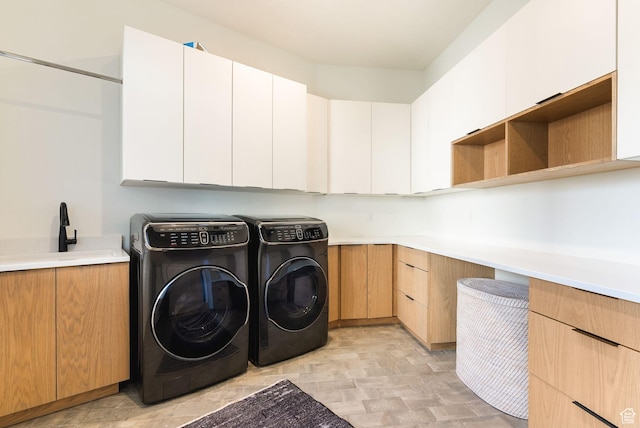 washroom featuring a sink, cabinet space, light floors, and washing machine and dryer