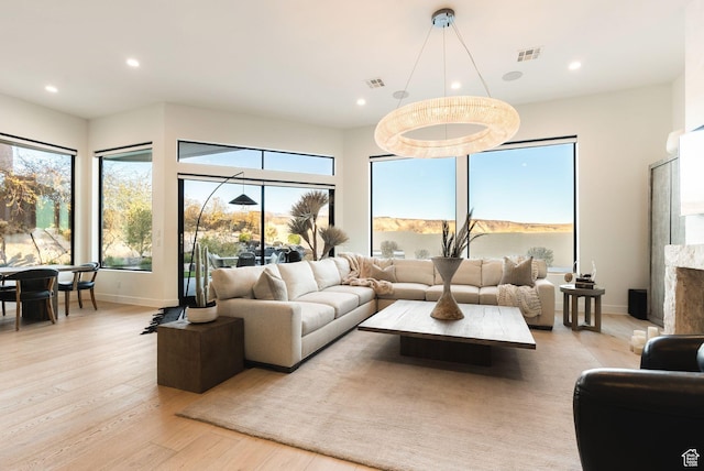 living area with recessed lighting, visible vents, light wood-style flooring, and baseboards