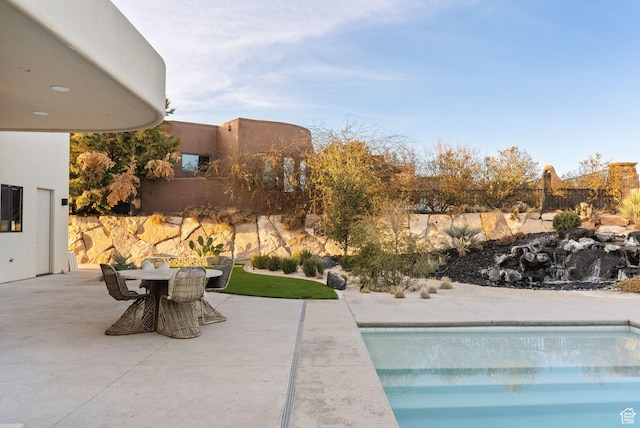 pool featuring outdoor dining area, fence, and a patio area