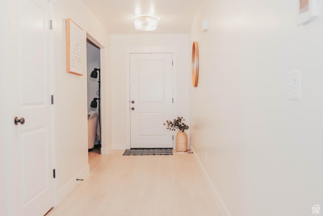 hallway featuring wood finished floors and baseboards