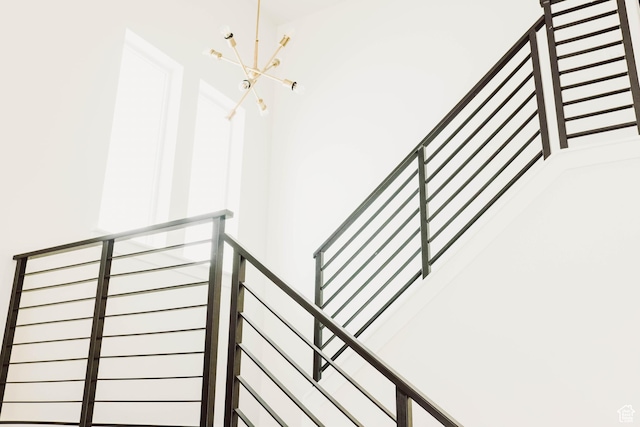 stairway featuring a notable chandelier