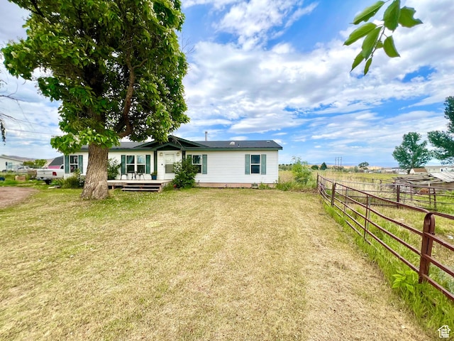 back of house featuring a wooden deck, a yard, and fence