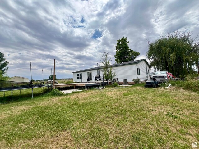 1568 N 750 E, Vernal, UT 84078 - back of house with a deck, a trampoline, central AC unit, and a yard