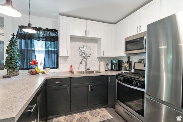 1333 S Lorl Ln E Unit 6, Ogden, UT 84404 - kitchen with a sink, tasteful backsplash, white cabinetry, appliances with stainless steel finishes, and light countertops