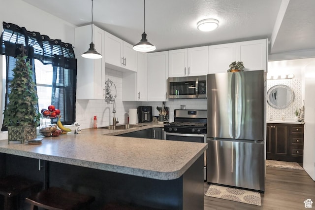 1333 S Lorl Ln E Unit 6, Ogden, UT 84404 - kitchen featuring dark wood-style floors, a peninsula, a sink, appliances with stainless steel finishes, and white cabinetry