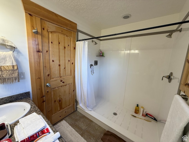 8043 E Badger Dr N, Heber City, UT 84032 - bathroom featuring a stall shower, a textured ceiling, a sink, and tile patterned floors