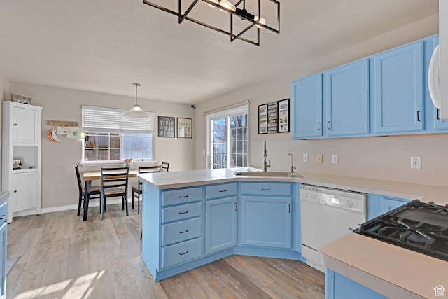 518 W 1330 N, Logan, UT 84341 - kitchen featuring white dishwasher, a sink, blue cabinets, and a peninsula