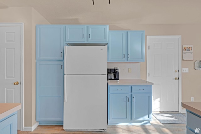 518 W 1330 N, Logan, UT 84341 - kitchen featuring freestanding refrigerator, blue cabinetry, light countertops, and baseboards