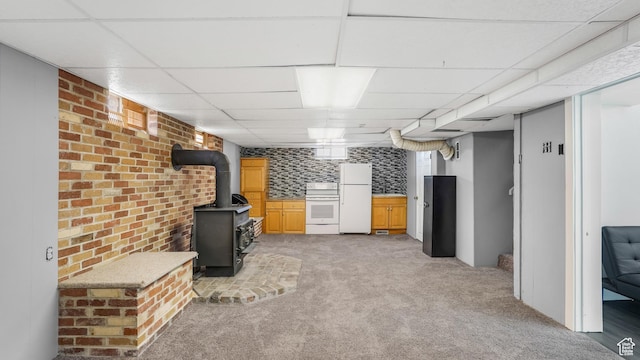 5460 S 4360 W, Kearns, UT 84118 - finished below grade area with freestanding refrigerator, brick wall, a paneled ceiling, light colored carpet, and a wood stove