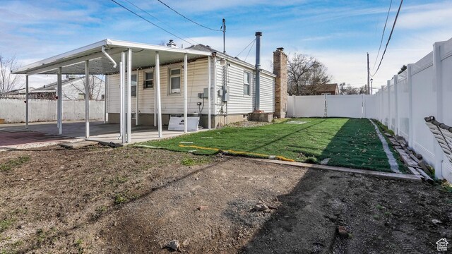 5460 S 4360 W, Kearns, UT 84118 - exterior space with a patio, a fenced backyard, a yard, an attached carport, and a chimney