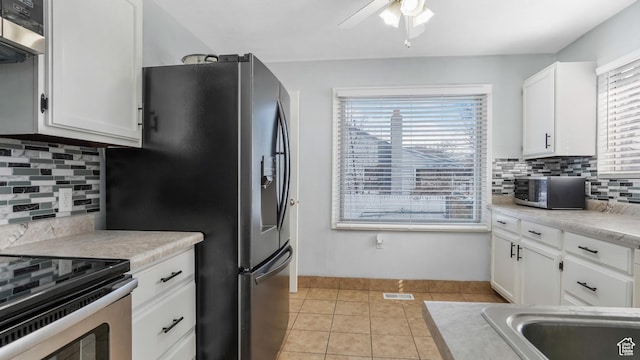 5460 S 4360 W, Kearns, UT 84118 - kitchen with light tile patterned floors, white cabinetry, stainless steel appliances, and a wealth of natural light