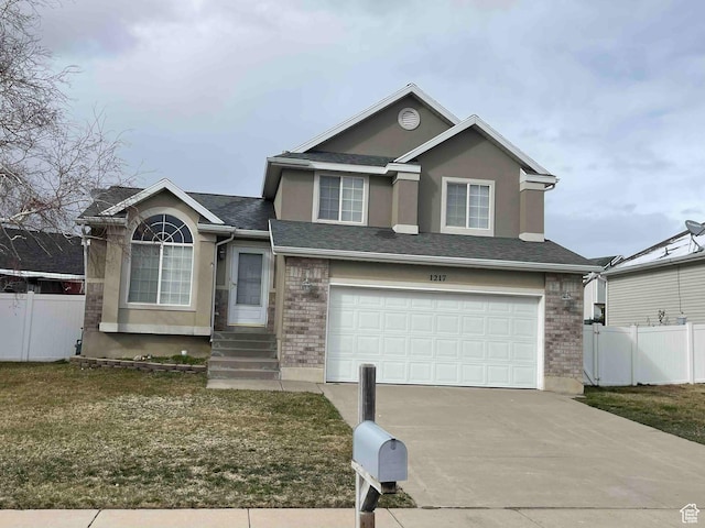 1217 E 3025 N, Layton, UT 84040 - view of front of home with a garage, brick siding, driveway, and fence