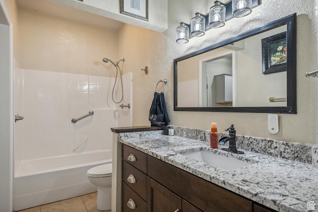bathroom with tile patterned flooring, toilet, shower / tub combination, a textured wall, and vanity